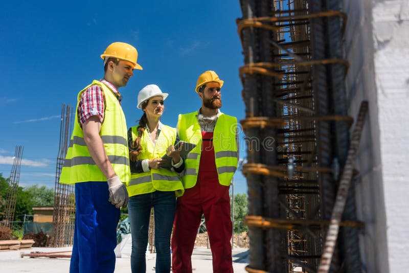 Architektenüberwachungsarbeit über die Baustelle eines Gebäudes stockbilder