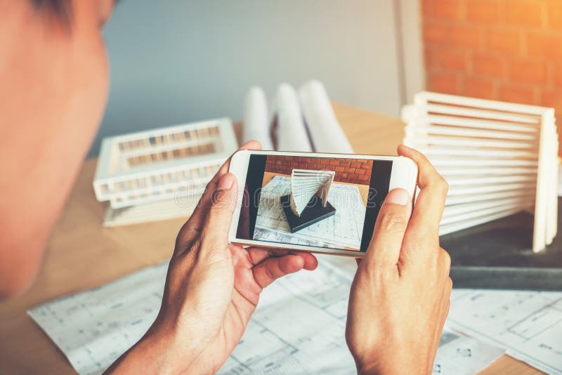 Architetto che utilizza il Modellismo della fotografia dello Smart Phone nell'ufficio fotografie stock Architetto che utilizza il Modellismo della fotografia dello Smart Phone nell'ufficio fotografie stock