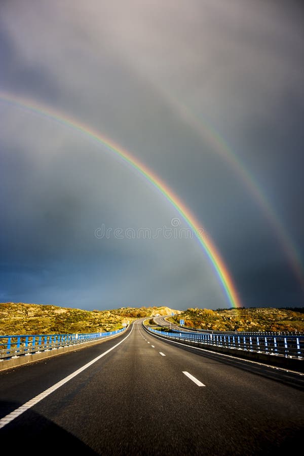 Arco-íris dobro sobre a estrada fotografia de stock Arco-íris dobro sobre a estrada fotografia de stock