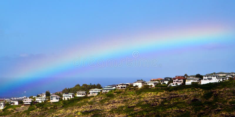 Rainbow hangs over ridgeline homes at a residential neighborhood in Honolulu, Hawaii. Rainbow hangs over ridgeline homes at a residential neighborhood in Honolulu, Hawaii