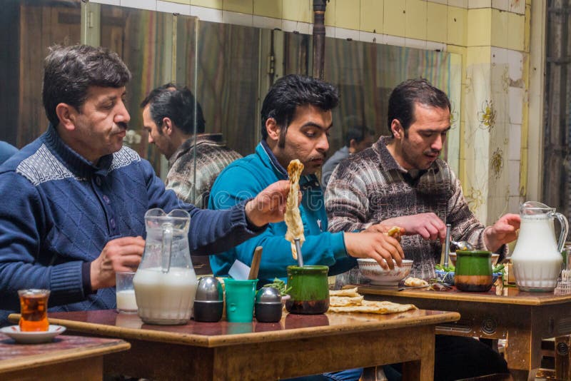 ARDABIL, IRAN - APRIL 10, 2018: People eat Dizi Abgoosht , traditional Iranian stew, in a local tea house in Ardabil, Ir
