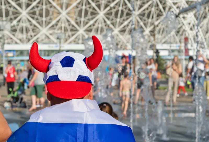 An ardent football fan stands in front of the stadium