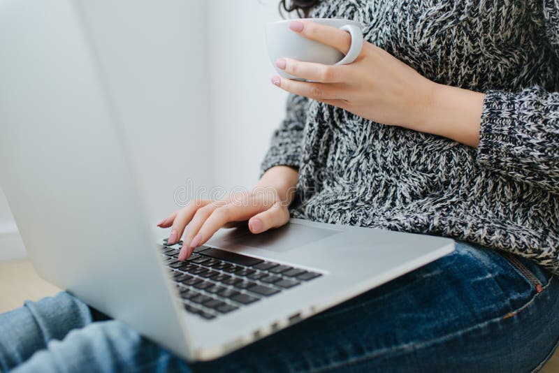 Area di lavoro con la mano della ragazza sulla tastiera del computer portatile immagine stock Area di lavoro con la mano della ragazza sulla tastiera del computer portatile immagine stock