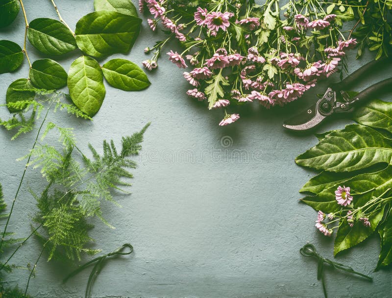 Area di lavoro del fiorista con molti foglie verdi fresche, fiori rosa e tagli, disposizione piana, struttura fotografia stock Area di lavoro del fiorista con molti foglie verdi fresche, fiori rosa e tagli, disposizione piana, struttura fotografia stock