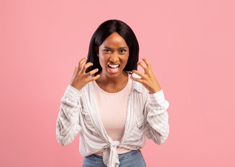 Angry black woman screaming out loud, tired of her problems, expressing negative emotions over pink studio background. Mad African American female yelling at camera. Angry black woman screaming out loud, tired of her problems, expressing negative emotions over pink studio background. Mad African American female yelling at camera