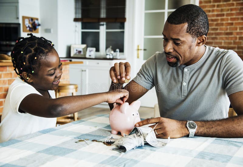 Argent d'économie de papa et de fille vers la tirelire photo stock Argent d'économie de papa et de fille vers la tirelire photo stock