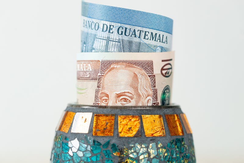 Guatemala money, quetzales banknotes sticking out from a decorative bowl, Financial concept, Financial savings, home budget, close up. Guatemala money, quetzales banknotes sticking out from a decorative bowl, Financial concept, Financial savings, home budget, close up