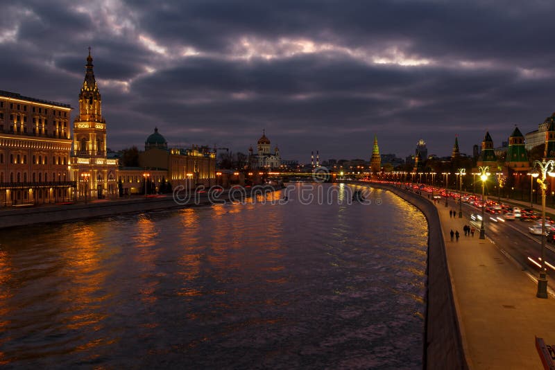 Argini del fiume di Moskva contro il Cremlino di Mosca su un fondo del cielo nuvoloso alla sera Paesaggio della città immagine stock Argini del fiume di Moskva contro il Cremlino di Mosca su un fondo del cielo nuvoloso alla sera Paesaggio della città immagine stock