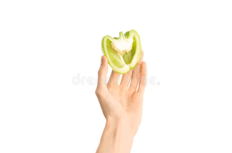 Argomento sano di dieta e di cibo: Il mezzo peperone verde della tenuta umana della mano isolato su un fondo bianco nello studio immagini stock