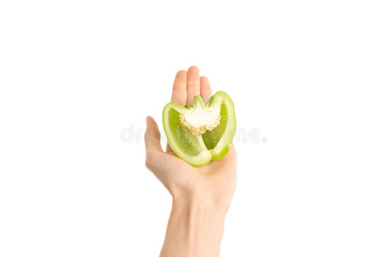 Argomento sano di dieta e di cibo: Il mezzo peperone verde della tenuta umana della mano isolato su un fondo bianco nello studio fotografia stock