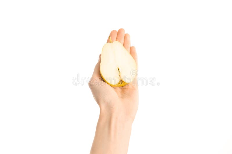 Argomento sano di dieta e di cibo: La mano umana giudica la metà della pera isolata su un fondo bianco nello studio, vista in pri fotografia stock libera da diritti