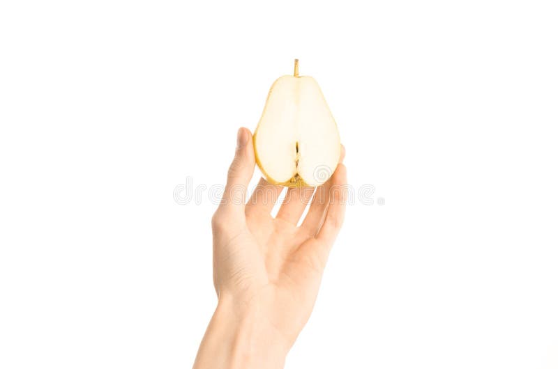 Argomento sano di dieta e di cibo: La mano umana giudica la metà della pera isolata su un fondo bianco nello studio, vista in pri fotografia stock
