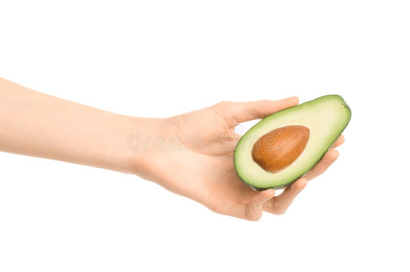 Argomento sano di dieta e di cibo: Mano umana che giudica un mezzo avocado isolato su un fondo bianco nello studio immagine stock