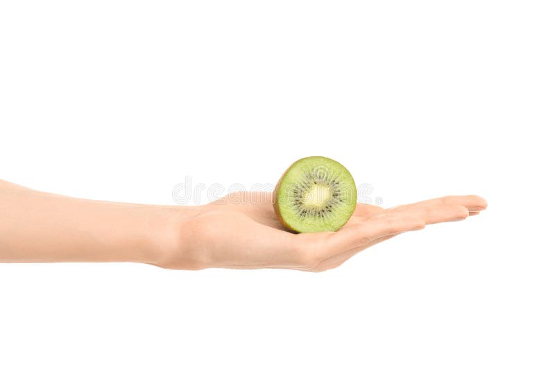 Argomento sano di dieta e di cibo: Mano umana che giudica un mezzo kiwi isolato su un fondo bianco nello studio immagine stock libera da diritti