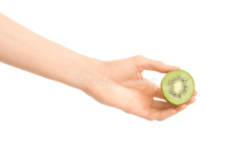 Argomento sano di dieta e di cibo: Mano umana che giudica un mezzo kiwi isolato su un fondo bianco nello studio immagine stock