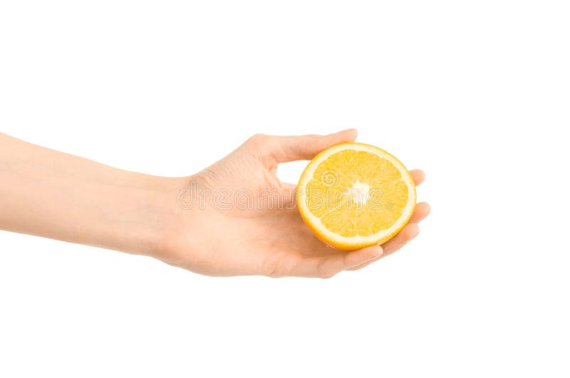 Argomento sano di dieta e di cibo: Mano umana che giudica una metà dell'arancia isolata su un fondo bianco nello studio immagini stock libere da diritti