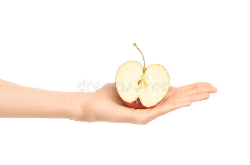 Argomento sano di dieta e di cibo: Mano umana che giudica una metà della mela rossa isolata su un fondo bianco nello studio immagini stock libere da diritti