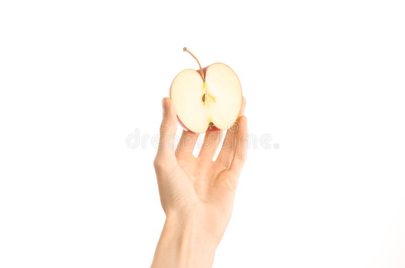 Argomento sano di dieta e di cibo: Mano umana che giudica una metà della mela rossa isolata su un fondo bianco nello studio, v in fotografia stock libera da diritti