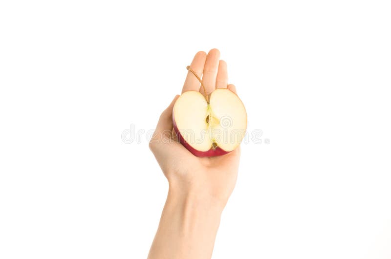 Argomento sano di dieta e di cibo: Mano umana che giudica una metà della mela rossa isolata su un fondo bianco nello studio, v in immagine stock libera da diritti