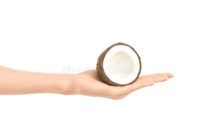 Argomento sano di dieta e di cibo: Mano umana che giudica una metà della noce di cocco isolata su un fondo bianco nello studio fotografie stock