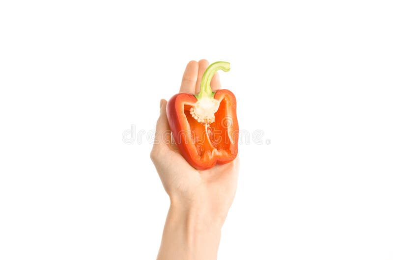 Argomento sano di dieta e di cibo: Mano umana che giudica una metà di peperone isolata su un fondo bianco nello studio, in prima immagine stock libera da diritti