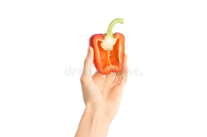 Argomento sano di dieta e di cibo: Mano umana che giudica una metà di peperone isolata su un fondo bianco nello studio, in prima fotografia stock libera da diritti