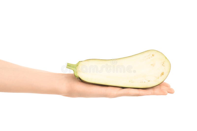 Argomento sano di dieta e di cibo: Mano umana che giudica una mezza melanzana isolata su un fondo bianco nello studio immagini stock libere da diritti
