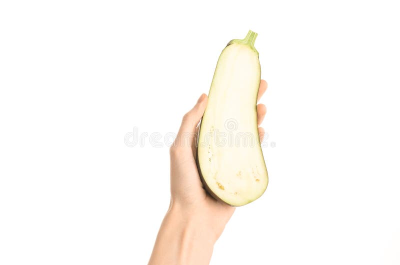 Argomento sano di dieta e di cibo: Mano umana che giudica una mezza melanzana isolata su un fondo bianco nello studio, vista in p immagine stock libera da diritti