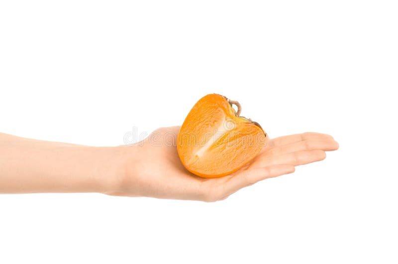 Argomento sano di dieta e di cibo: Mano umana che tiene una metà dei cachi isolati su fondo bianco nello studio fotografia stock libera da diritti