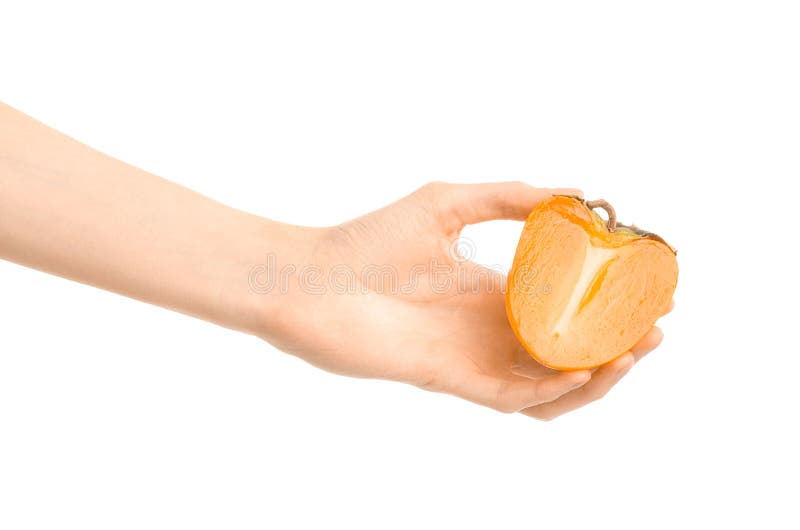 Argomento sano di dieta e di cibo: Mano umana che tiene una metà dei cachi isolati su fondo bianco nello studio fotografia stock libera da diritti