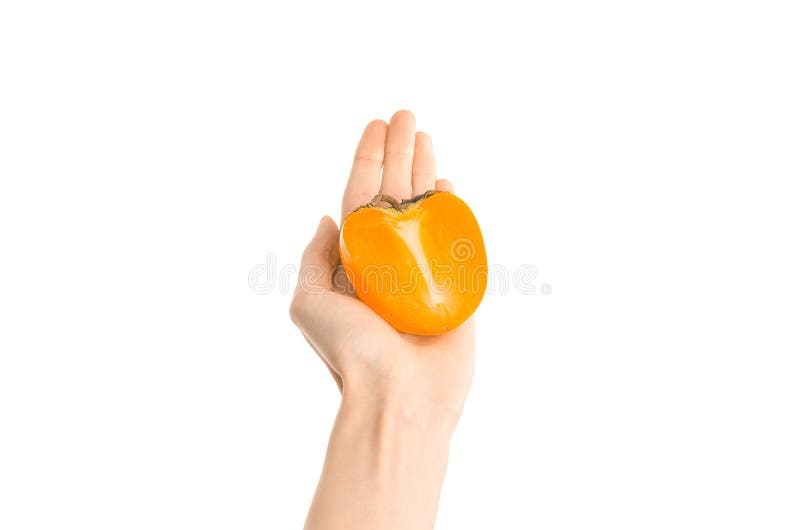 Argomento sano di dieta e di cibo: Mano umana che tiene una metà dei cachi isolati su fondo bianco nello studio, vi in prima pers fotografia stock libera da diritti