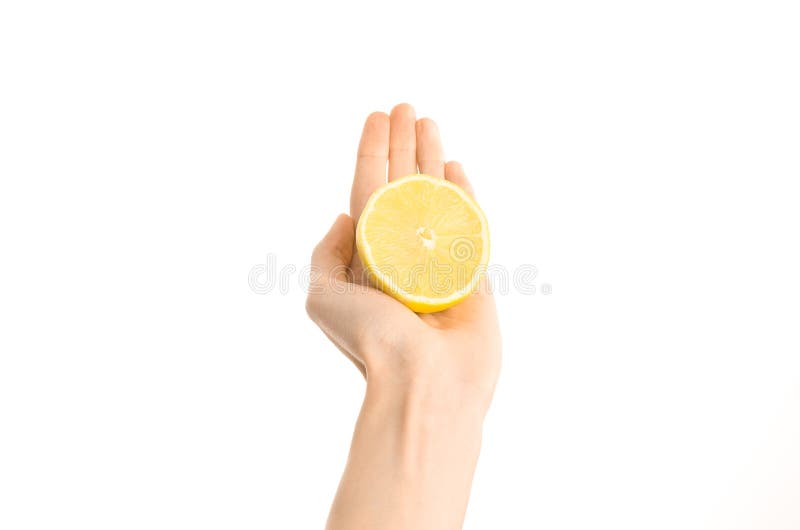 Argomento sano di dieta e di cibo: Metà umana della tenuta della mano del limone isolata su un fondo bianco nello studio, vista i fotografia stock