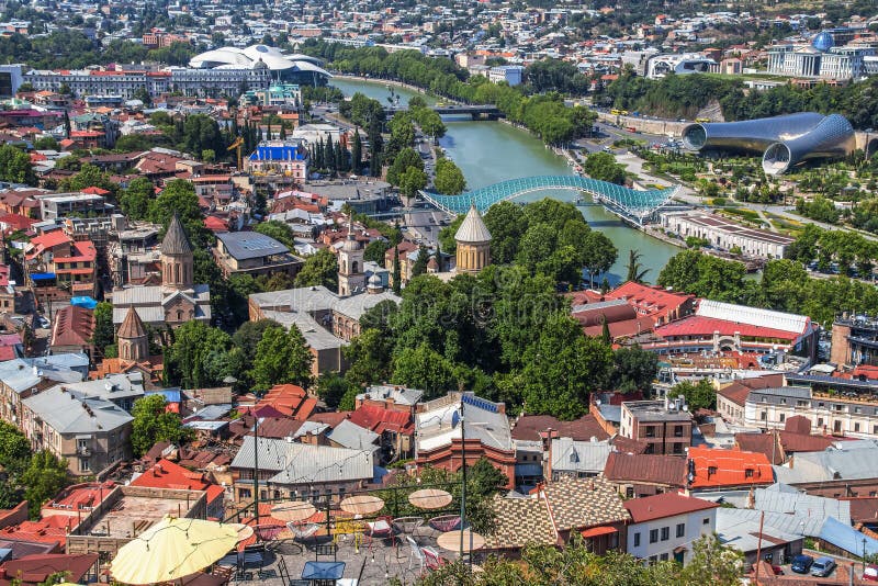 Arias syn på Tbilisi skyline med floden Kura och fredens bro och andra antika och moderna byggnader och broar royaltyfri foto