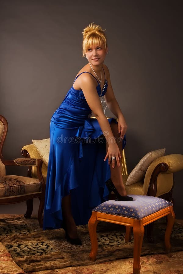 Aristocratic lady in a dark blue dress in a luxurious boudoir