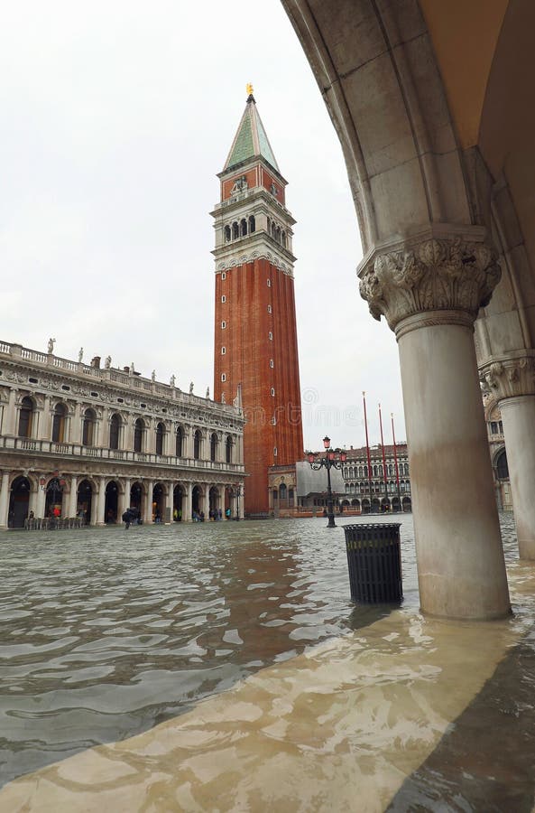 Arkade des Dogenpalastes in Venedig und Glockenturm des Markuses während einer Flut stockbilder