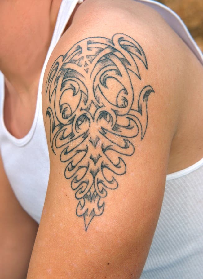 Mladý muž sa zobrazí jeho tetovanie na jeho rameno.