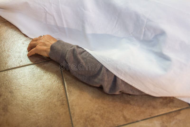 Arm från en avliden kvinna som kommer ut ur det vita bladet brukade täcka kroppen arkivfoto Arm från en avliden kvinna som kommer ut ur det vita bladet brukade täcka kroppen arkivfoto