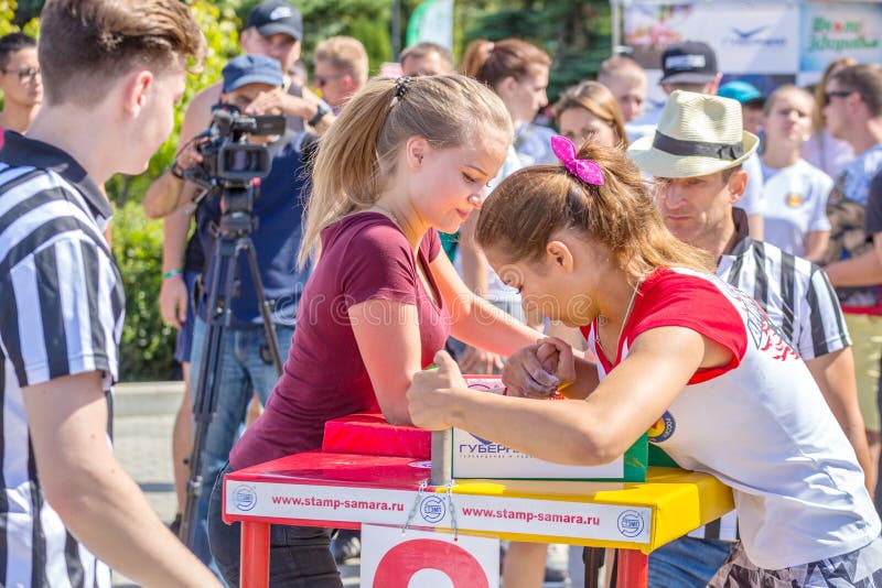 Arm wrestling among girls on the Volga River Embankment on a sunny summer day