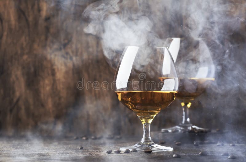 Armagnac, French grape brandy, strong alcoholic drink. Still life in vintage style with cigar smoke, copy space