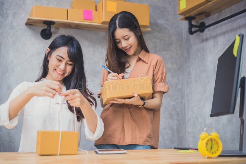 Armazém de distribuição startup de dois SME do empresário da empresa de pequeno porte dos povos asiáticos novos com caixa postal fotografia de stock Armazém de distribuição startup de dois SME do empresário da empresa de pequeno porte dos povos asiáticos novos com caixa postal fotografia de stock