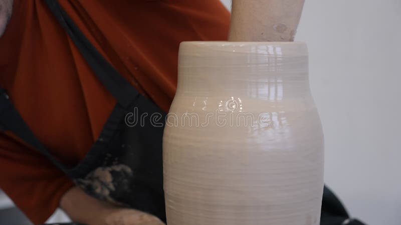 Armação de uma mão de cerâmica fazendo um vaso cerâmico em uma roda de cerâmica.