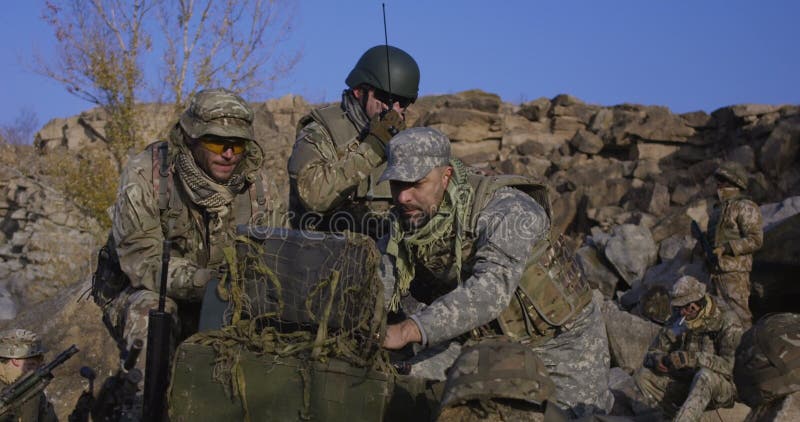 Armed soldiers looking at a computer