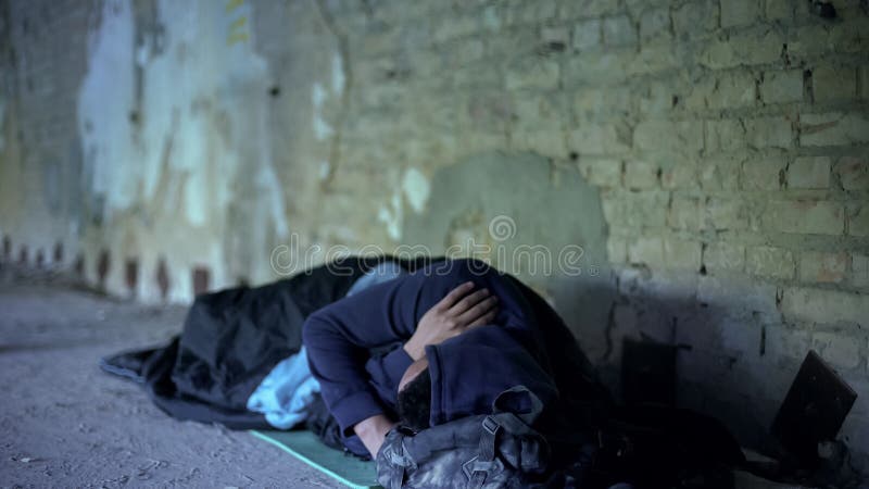 Armod hemlös ung man som sover på gatan, likgiltigt egoistiskt samhälle arkivbilder Armod hemlös ung man som sover på gatan, likgiltigt egoistiskt samhälle arkivbilder