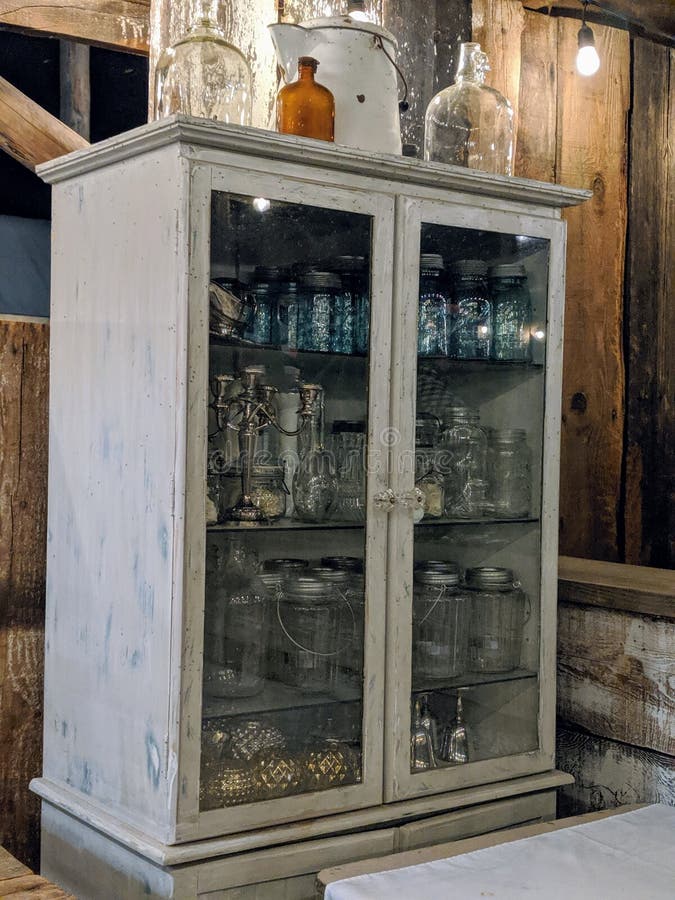 Armoire En Bois Antique Avec Portes En Verre Remplies De Vieux Jarres Et Bouteilles Dans Une Étoile photo stock Armoire En Bois Antique Avec Portes En Verre Remplies De Vieux Jarres Et Bouteilles Dans Une Étoile photo stock