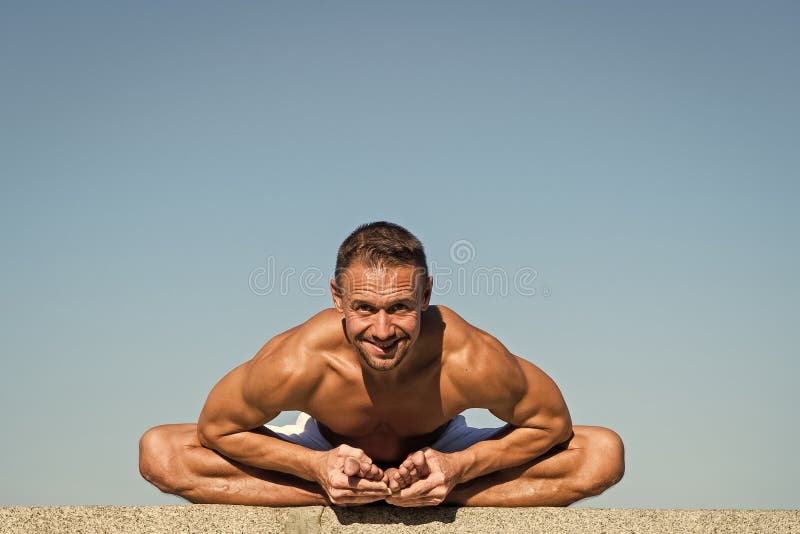 Armonia ed equilibrio del ritrovamento di aiuti di pratica di yoga Fondo di pratica del cielo blu di yoga dell'uomo Pace dello sp fotografie stock libere da diritti Armonia ed equilibrio del ritrovamento di aiuti di pratica di yoga Fondo di pratica del cielo blu di yoga dell'uomo Pace dello sp fotografie stock libere da diritti