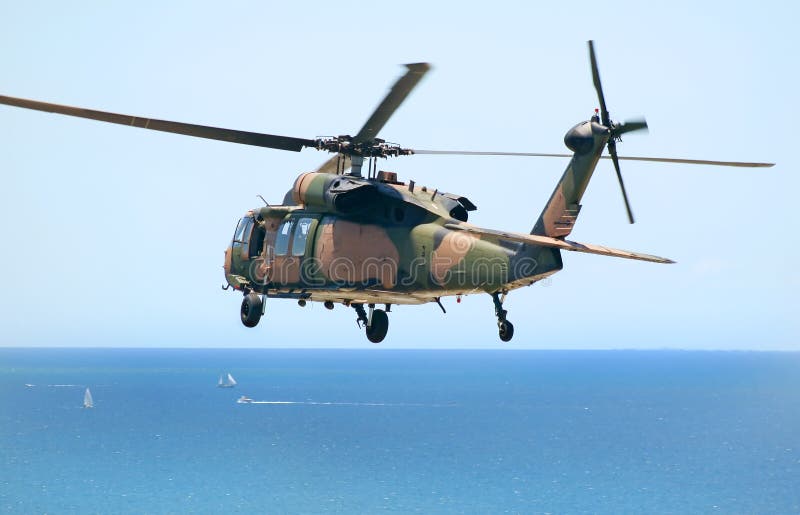 Australian Army Blackhawk chopper flies over the Pacific Ocean.