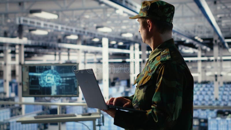 Army soldier in server farm uses artificial intelligence program on laptop stock video