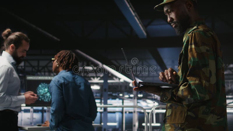 Army technician in command center server room using laptop stock video