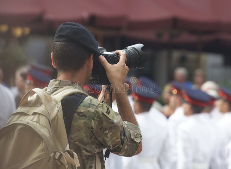 Arméfotografen tar bilder av lödmetaller i fyrkanten, fotografen i handling arkivfoto Arméfotografen tar bilder av lödmetaller i fyrkanten, fotografen i handling arkivfoto
