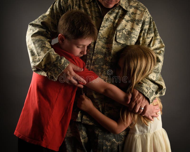 Armésoldatfader Hugging Family hemma royaltyfri fotografi Armésoldatfader Hugging Family hemma royaltyfri fotografi